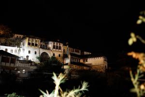Un grand bâtiment est éclairé la nuit. dans l'établissement A&Fabio Guesthouse, à Gjirokastër