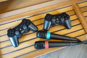 Ein Stift und vier Videospiel-Controller auf einem Tisch in der Unterkunft Orchard Bungalow - Sleeps 10 - Close to Town Centre - Free Parking, PlayStation, Fast Wi-Fi and Smart TV with Netflix by Yoko Property in Northampton