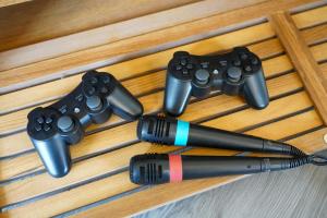 a pen and four video game controllers on a table at Orchard Bungalow - Sleeps 10 - Close to Town Centre - Free Parking, PlayStation, Fast Wi-Fi and Smart TV with Netflix by Yoko Property in Northampton