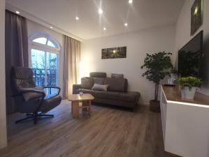 a living room with a couch and a chair at Apartmenthaus Atlantik in Kühlungsborn