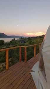 una terraza de madera con vistas al océano. en Cabaña y Domos Ollagua con vista al lago en Cholila