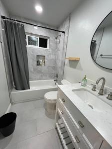 a bathroom with a sink and a tub and a toilet at Tao house in La Verne