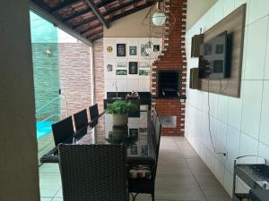 - une salle à manger avec une table, des chaises et une piscine dans l'établissement Quarto em casa de condominio fechado, à Santarém