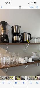 a shelf with dishes and a blender on it at Apart Aconchego Mobiliado até 4 pessoas Centro in Sinop