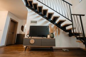 a living room with a tv and a staircase at Cabana A-Frame NorthLand in Borşa