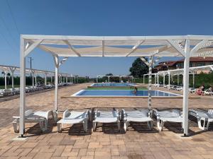 um grupo de cadeiras e uma piscina com um pavilhão em Chateau Aheloy 2, apartment with sea view em Aheloy