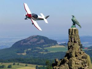 un piccolo aereo che vola sopra una formazione rocciosa con la statua di un uccello di Gasthof Rhönlust a Bischofsheim an der Rhön