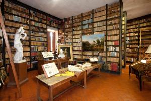 uma biblioteca com muitos livros nas prateleiras em Le "spacieux" en centre ville em Carpentras
