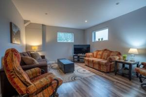 a living room with two couches and a tv at Chalet des Érables-3 bedrooms, jacuzzi & relax in Petite-Rivière-Saint-François