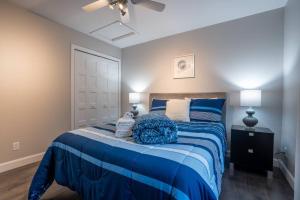 sypialnia z niebiesko-białym łóżkiem z 2 lampami w obiekcie Chalet des Érables-3 bedrooms, jacuzzi & relax w mieście Petite-Rivière-Saint-François