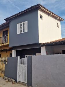 a blue and white house with a fence at Casa Celeste Búzios in Búzios