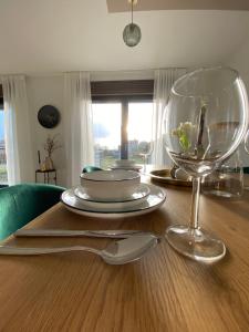 un tavolo in legno con un piatto e bicchieri da vino sopra di FeWo Max Nähe HUK, neu eingerichtet und renoviert a Coburg