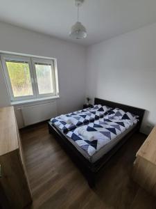 a bedroom with a bed in a room with two windows at Domek Bocianie Gniazdo in Stradomka