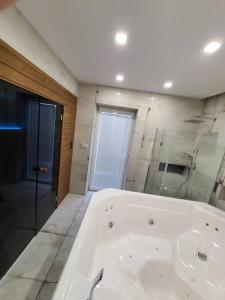 a large white bath tub in a bathroom at Domek Bocianie Gniazdo in Stradomka +26 photos