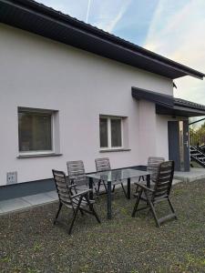 a table and chairs in front of a house at Domek Bocianie Gniazdo in Stradomka