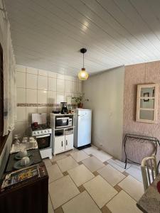 uma cozinha com fogão e geladeira em Casa com suíte em Blumenau