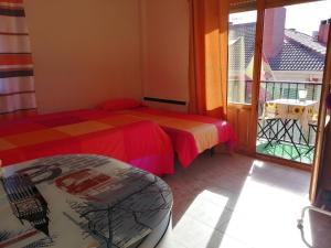 a room with two beds and a balcony at Habitación privada, siéntete como en tu casa in Manzanares el Real