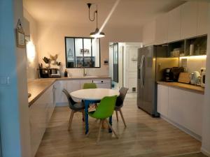 cocina con mesa y sillas en una habitación en Chez Nadège et Nicolas, en Aubergenville