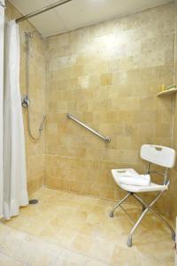 La salle de bains est pourvue d'une douche, de toilettes et d'une chaise. dans l'établissement HB Xalapa, à Xalapa