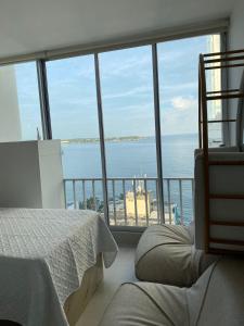 een slaapkamer met uitzicht op de oceaan vanaf een balkon bij Apartamento con hermosa vista al mar, Cristoforo en el Laguito Cartagena a pocos pasos de la playa in Cartagena