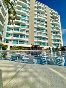 un gran edificio de apartamentos con piscina frente a él en Edificio Aragoa, Rodadero sur, santa Marta, en Santa Marta