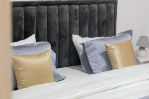 łóżko z niebiesko-białymi poduszkami w obiekcie ESPACE VIRAGE w mieście Dakar