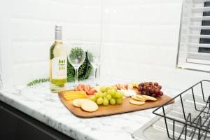 a cutting board with fruit and wine glasses on a counter at Stylish home in York - Free Wifi & Parking - Close to Racecourse & City Centre in York