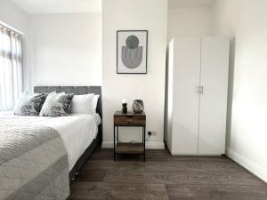 a bedroom with a bed and a night stand next to a door at Stylish home in York - Free Wifi & Parking - Close to Racecourse & City Centre in York