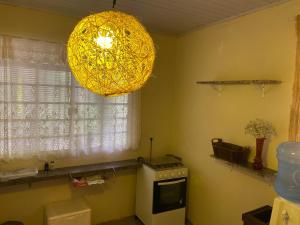 a kitchen with a chandelier hanging over a stove at Casa Saracura in Aguaçu