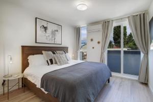 a bedroom with a large bed and a large window at Gorgeous NEW Townhome on Capitol Hill, Close to Everything! in Seattle