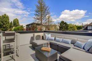 a patio with a couch and a table on a roof at Gorgeous NEW Townhome on Capitol Hill, Close to Everything! in Seattle