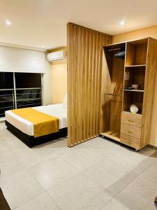 Puerto Gaitán的住宿－Hotel Payara，一间卧室配有一张床和一个木制衣柜