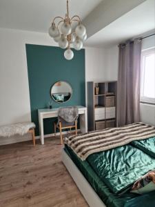 een slaapkamer met een bed, een bureau en een spiegel bij Ella Green Apartments in Gratkorn