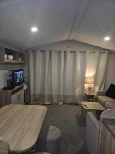 een woonkamer met een tent met een bank en een tv bij Jenny,s place in Saint Osyth