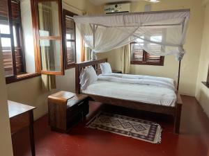 a bedroom with a bed with a canopy at Bin Omiar Malindi Apartment in Stone Town