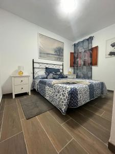 een slaapkamer met een bed en een houten vloer bij Casa Lucia in Puerto del Carmen