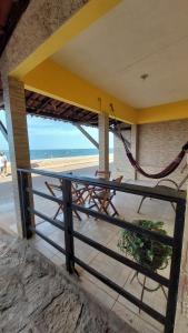 uma varanda com uma mesa e vista para a praia em Chalés Canto do Mar em Redonda