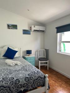 a bedroom with a bed and a chair and a window at Mar Rosa - Terraço Vista Praia in Horta