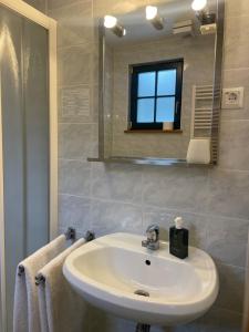 a bathroom with a white sink and a mirror at Apartment on the ski slope Pohorje 11 in Hočko Pohorje +40 photos