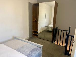 a bedroom with a mirror and a bed in a room at Self Contained 1 Bedroom Duplex in Leicester