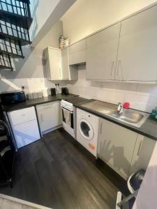 uma cozinha com um lavatório e uma máquina de lavar roupa em Self Contained 1 Bedroom Duplex em Leicester