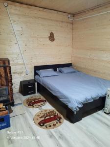 a bedroom with a bed and two pizzas on the floor at Cabana Larisa in Armeniş
