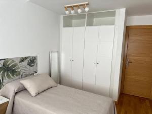 a bedroom with a bed and a large white cabinet at Studio 14 + garaje incluido. Nuevo, elegante, acogedor. in Haro