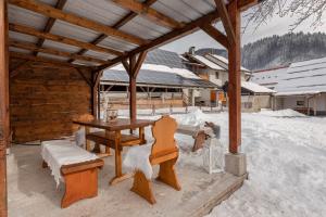 un pabellón de madera con mesa y sillas en la nieve en Deluxe Apartments 55, en Rateče