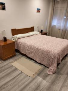 a bedroom with a bed and a dresser and a table at Casa Raquelina in Gijón