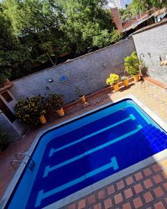a blue swimming pool with plants on a house at Hostal La Pola in Santa Fe de Antioquia