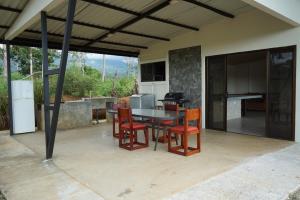 patio con mesa y sillas y cocina en Cabaña La Chavela 
