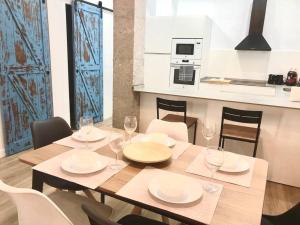 a dining room table with white plates and wine glasses at Duplex nueva construcción en Málaga-Centro in Málaga