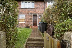 a brick house with a wooden door and a yard at Morden House in Morden