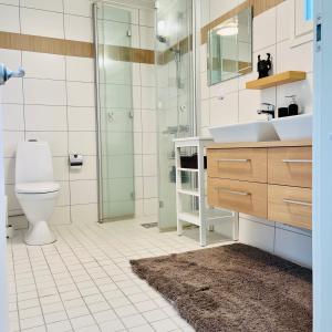 a bathroom with a toilet and a sink and a shower at Vuolenkosken Helmi - laadukas ympärivuotinen kohde in Huutotöyry